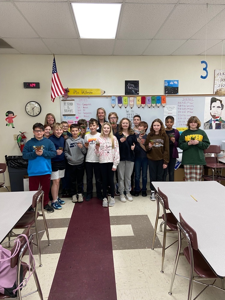 6th Grade Students hold plants with Growing Green Co